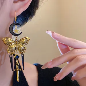 Detailed view of vintage moon and butterfly tassel earrings featuring a sword pendant.