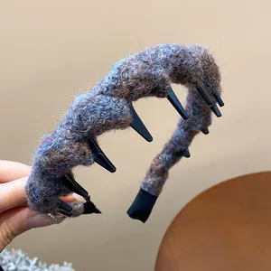 Detailansicht eines dicken gestrickten Wollhaarreifens mit integrierten schwarzen Styling-Zähnen.