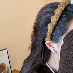 Nahaufnahme eines stylischen geflochtenen Stirnbandes aus Wolle in Herbstfarben für Damen.