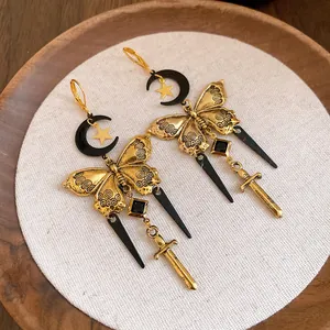 Detailed view of vintage gothic tassel earrings featuring moon, butterfly and sword charms