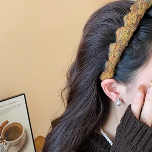 Nahaufnahme eines grob gestrickten Wollstirnbands mit Textur und High-Top-Styling.
