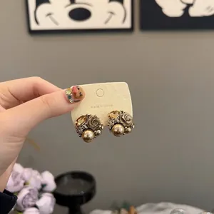 Close-up of vintage style floral stud earrings with pearls and amber crystals for women