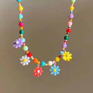 Detailaufnahme einer bunten Perlenkette mit lebendigen Harzblumen-Anhängern