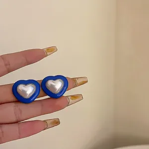 Elegant heart-shaped blue stud earrings with a central pearl inlay for fashion