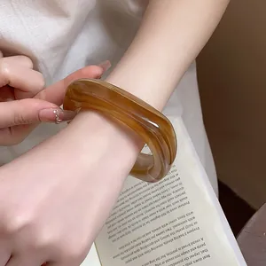 Close-up detail of amber tortoiseshell resin square bangle for women's fashion jewelry