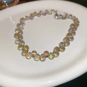 Nahaufnahme einer schimmernden facettierten Glasperlenkette auf einem Keramikteller