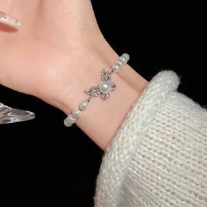 Elegant butterfly pearl bracelet with rhinestones worn on a delicate wrist