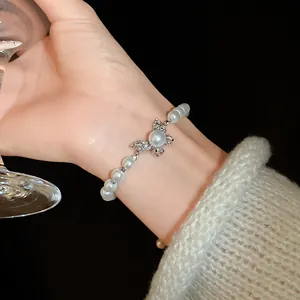 Close-up of a vintage butterfly pearl bracelet with rhinestone details on a wrist