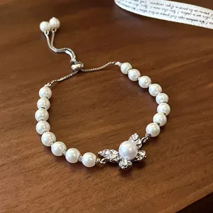 Detail of rhinestone butterfly charm on adjustable pearl bracelet for women