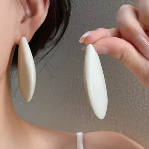 Dettaglio di orecchini a goccia bianco crema in stile vintage francese minimalista