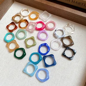 Close-up of colorful irregular geometric acrylic rings with artistic marbled patterns