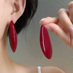Dettaglio ravvicinato di grandi orecchini a goccia rosso scuro lucidi in stile retrò francese