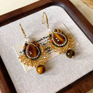 Detailed view of Maillard style faux tiger eye earrings with retro tassel and zircon accents
