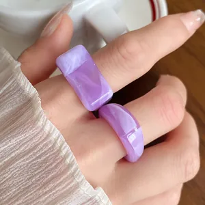 Detail view of purple marbled acrylic rings with unique geometric and irregular shapes.