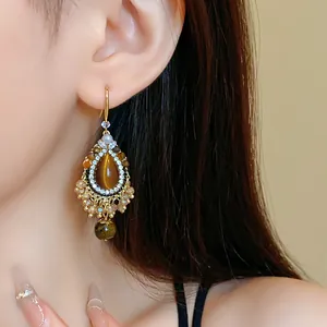 Macro view of vintage ethnic waterdrop earrings featuring faux tiger eye and tassels
