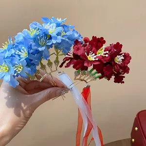 Vista detallada de horquillas artesanales de flores de tela azul y roja con cintas elegantes