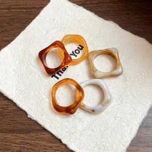 Detailed macro view of colorful marbled acrylic geometric rings on white textured paper
