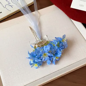Primer plano de una horquilla de flores de tela azul con cintas fluidas elegantes
