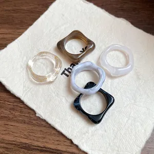 Detailed view of irregular acrylic rings with marbled and gold foil designs.