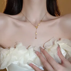 Close-up of elegant gold butterfly pendant necklace worn by a model in a white ruffled dress