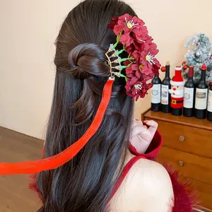 Detalle de horquilla de estilo chino con flores de tela roja oscura y borlas largas