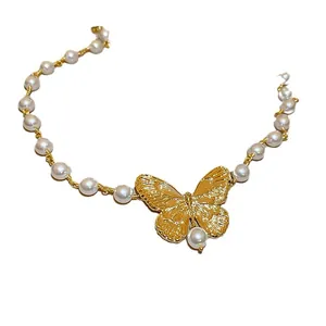Elegant gold butterfly pendant necklace with white pearl beads for a minimalist look
