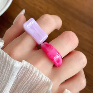 Detailed close-up showing the marbled texture of purple and pink acrylic geometric rings