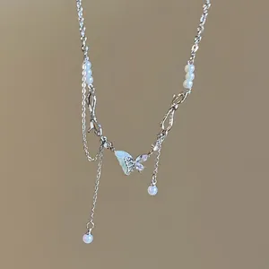 Detailed view of a dainty butterfly pendant necklace with elegant pearls and sparkling crystals