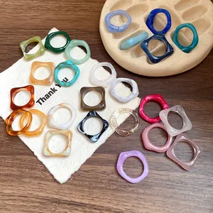 Close-up of colorful irregular marbled acrylic geometric rings on a display holder.
