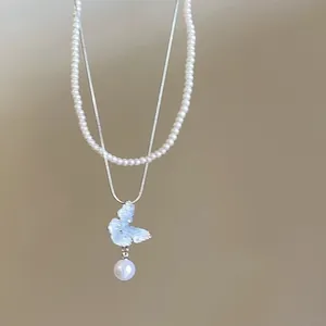 Elegant double-layered necklace featuring a textured butterfly and pearl pendant detail