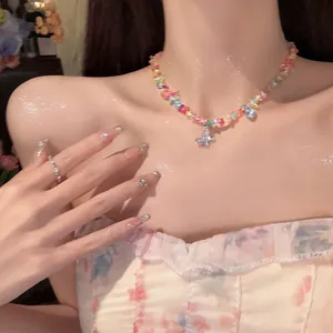 Close-up of a colorful beaded necklace with a sparkling butterfly pendant on a model.
