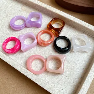 Top view of colorful acrylic marble geometric rings arranged on a stone display tray