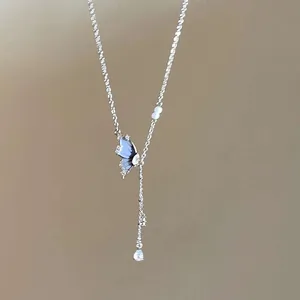 Close-up of minimalist silver butterfly pendant necklace with elegant pearl drop detail