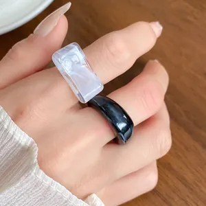 Close-up detail showing the textures of marbled black and white acrylic geometric rings