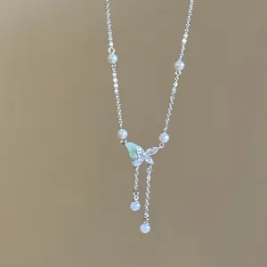 Detailed close-up view of a dainty silver butterfly necklace with pearls and tiny rhinestones