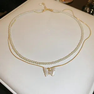 Detailed macro shot of elegant double-layered necklace featuring butterfly and pearls