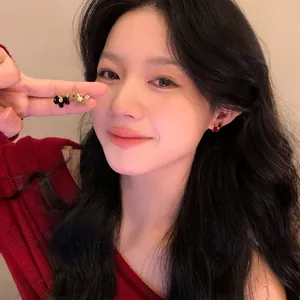 Detailed view of an Asian model wearing cute flocked horse stud earrings in various colors