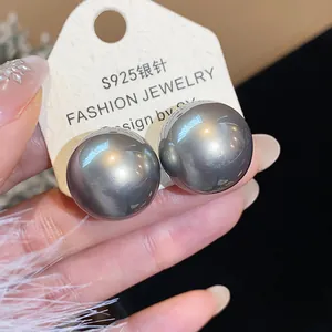 Dettaglio di grandi orecchini a perno con perle grigio metallizzato e perni in argento S925