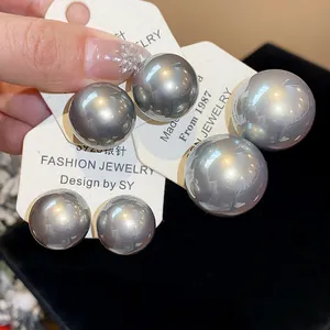 Primo piano di eleganti orecchini a perno con perle grigie metallizzate e aghi in argento S925