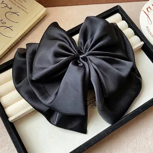 Elegant large black fabric bow hair claw clip with a sleek silk-like satin texture