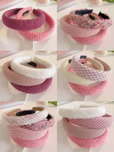 Detail view of assorted textured hairbands in soft pink, white, and purple colors