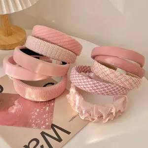 Detailed macro view showing variety of pink padded and tweed headbands styled on a magazine