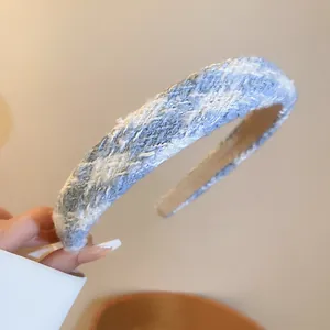 Close-up view of a blue and white tweed padded headband with woven fabric texture.