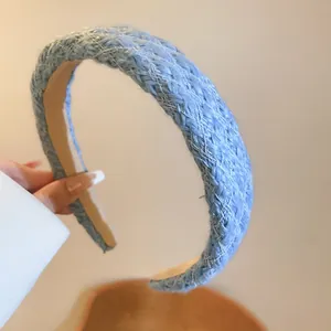 Detailed view of a light blue thick woven headband featuring a stylish braided texture