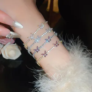 Détail rapproché des bracelets de tennis en zircon et papillon en or et argent