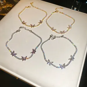 Gros plan sur d'élégants bracelets tennis en zircon doré et argenté avec papillons.