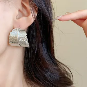 Dettaglio macro dell'orecchino a foglia d'argento con elegante finitura testurizzata