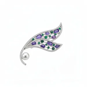 Elegante spilla a foglia traforata color argento con pietre viola e una lucente perla bianca