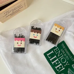 Set of black bobby pins in cute cartoon cases on white mesh for hair styling