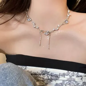 Close-up of irregular silver-tone necklace with pearls, rhinestones, and fringe tassels